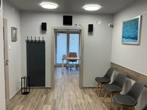 Poczekalnia gabinetu ginekologicznego w Koszalinie z krzesłami i przejściem do gabinetu konsultacyjnego.